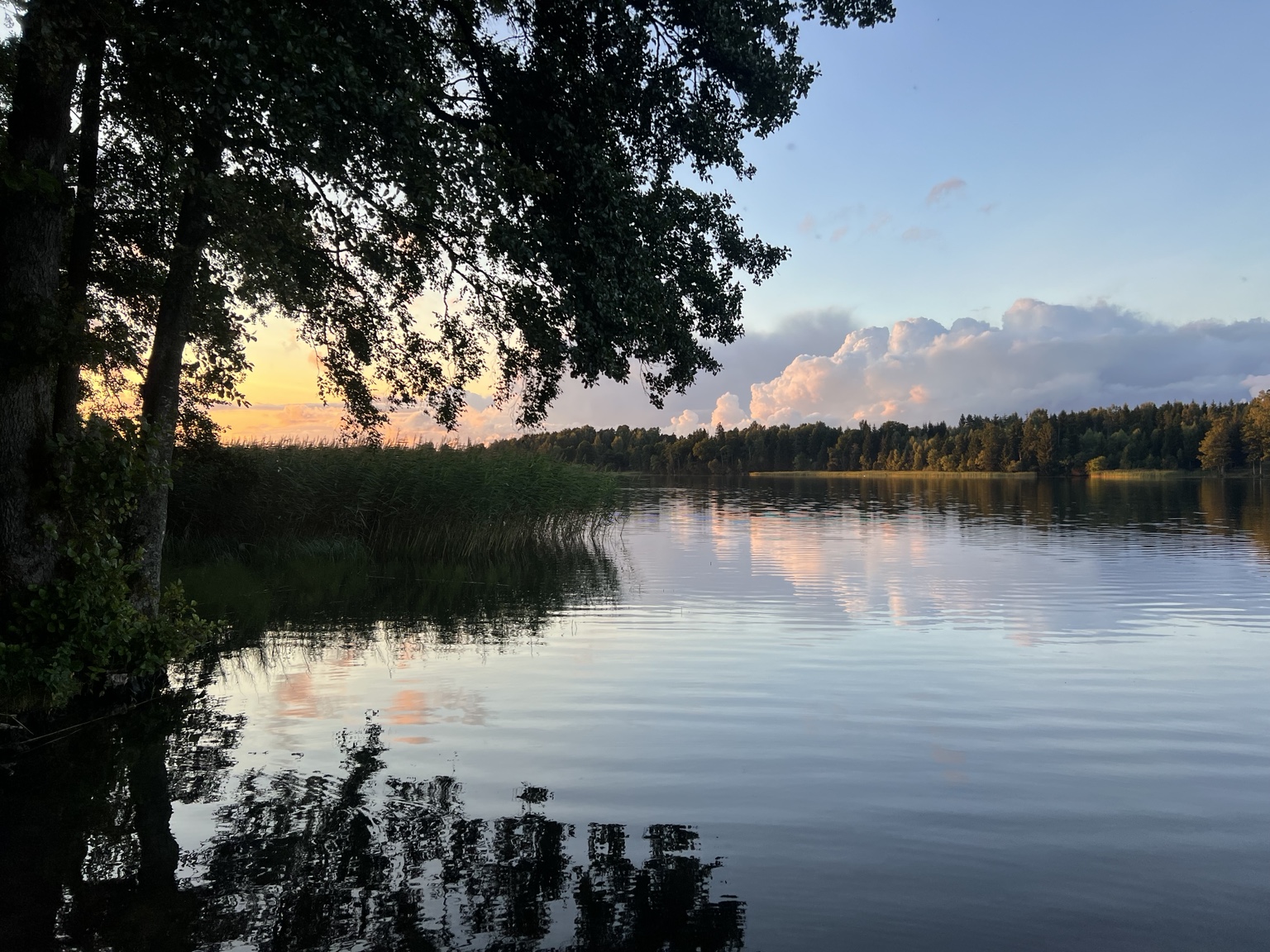 Soft evening light reflected across the lake at Ezermaļi