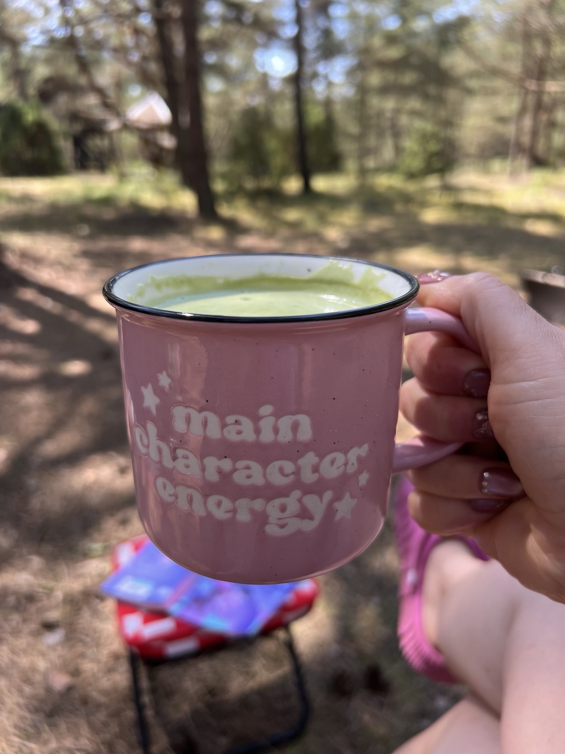 A camping mug beside the tent at Miera Osta