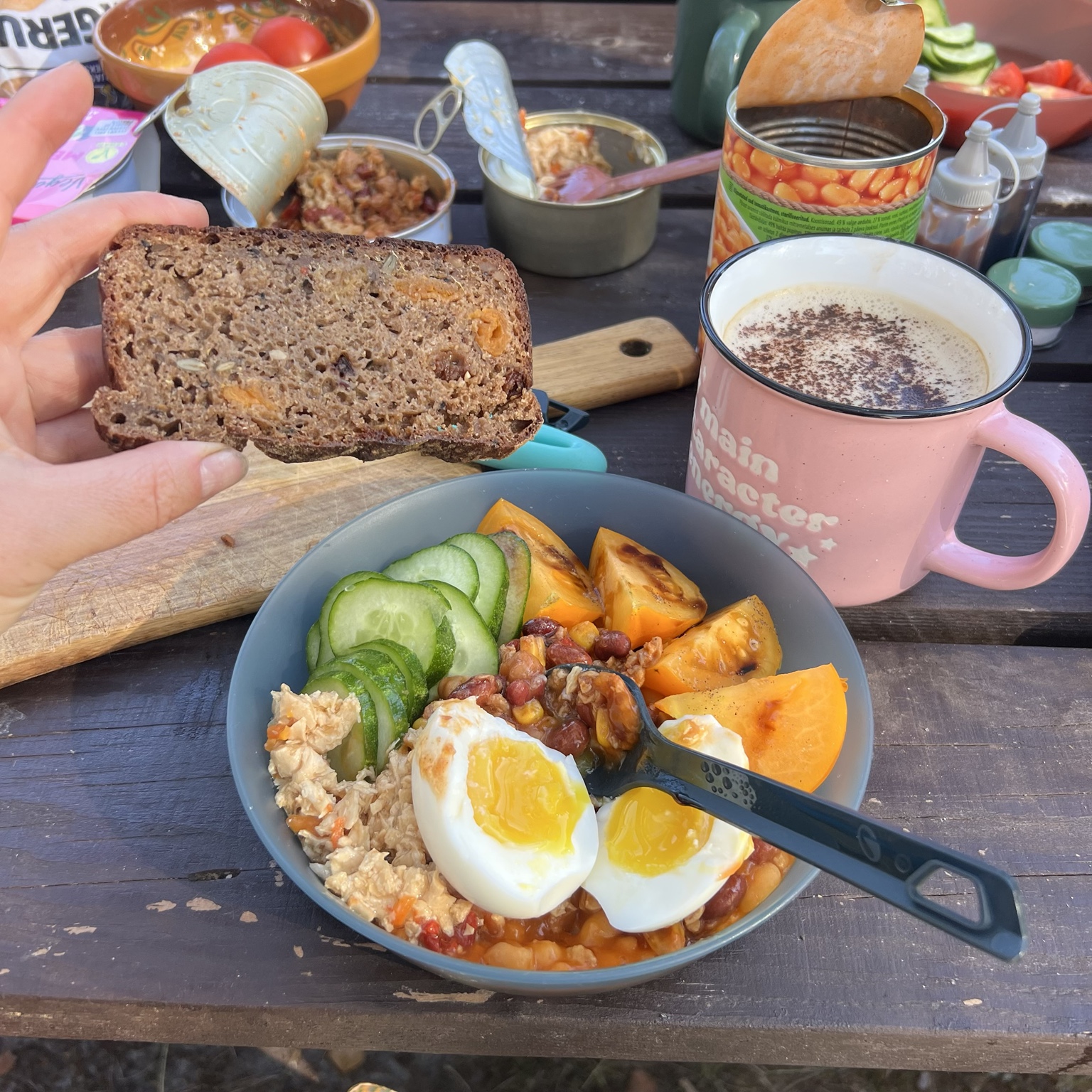 A campsite breakfast with egg, bean and soy salads, cucumber, tomatoes, bread and coffee