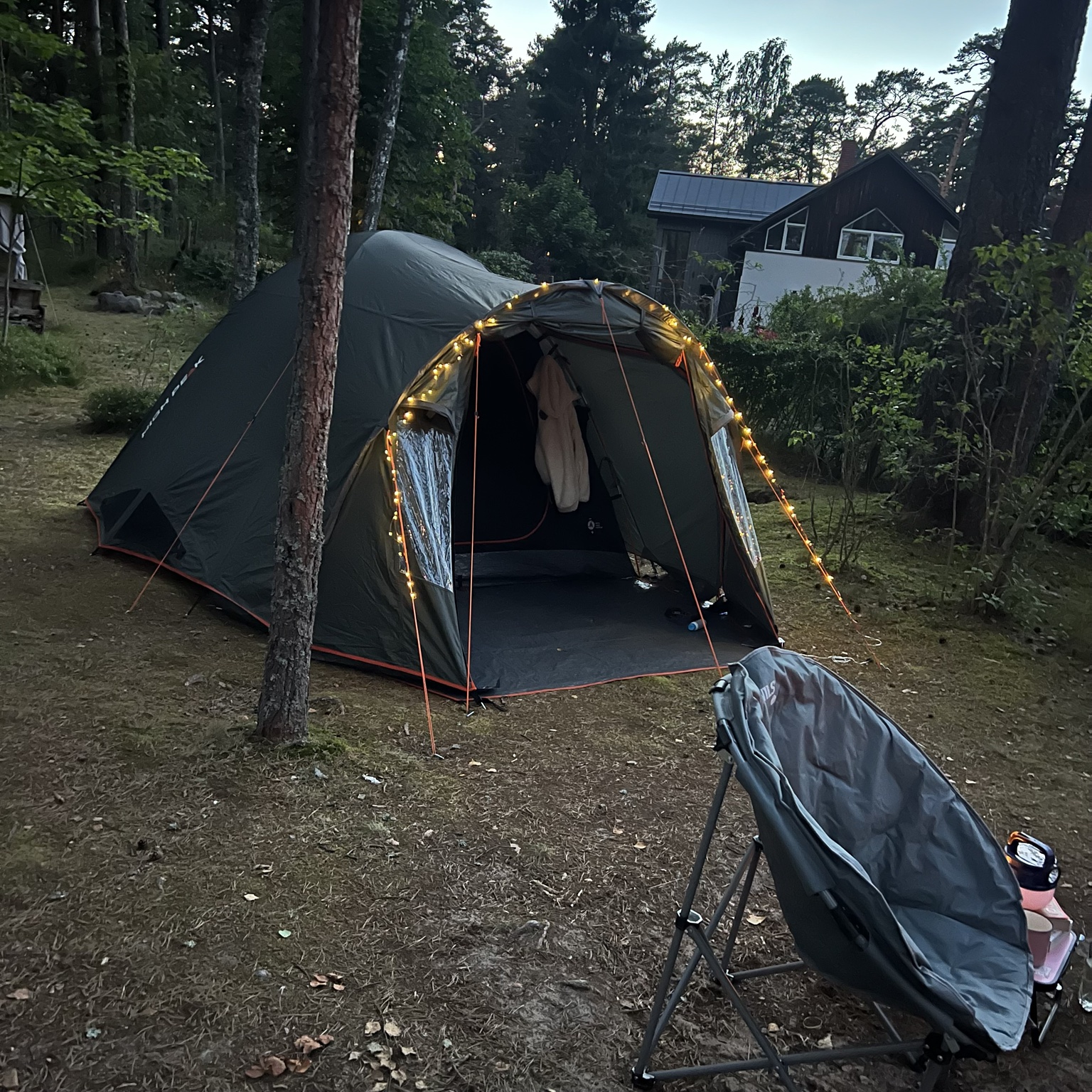 A tent glowing with warm fairy lights at dusk at Plaucaki campsite